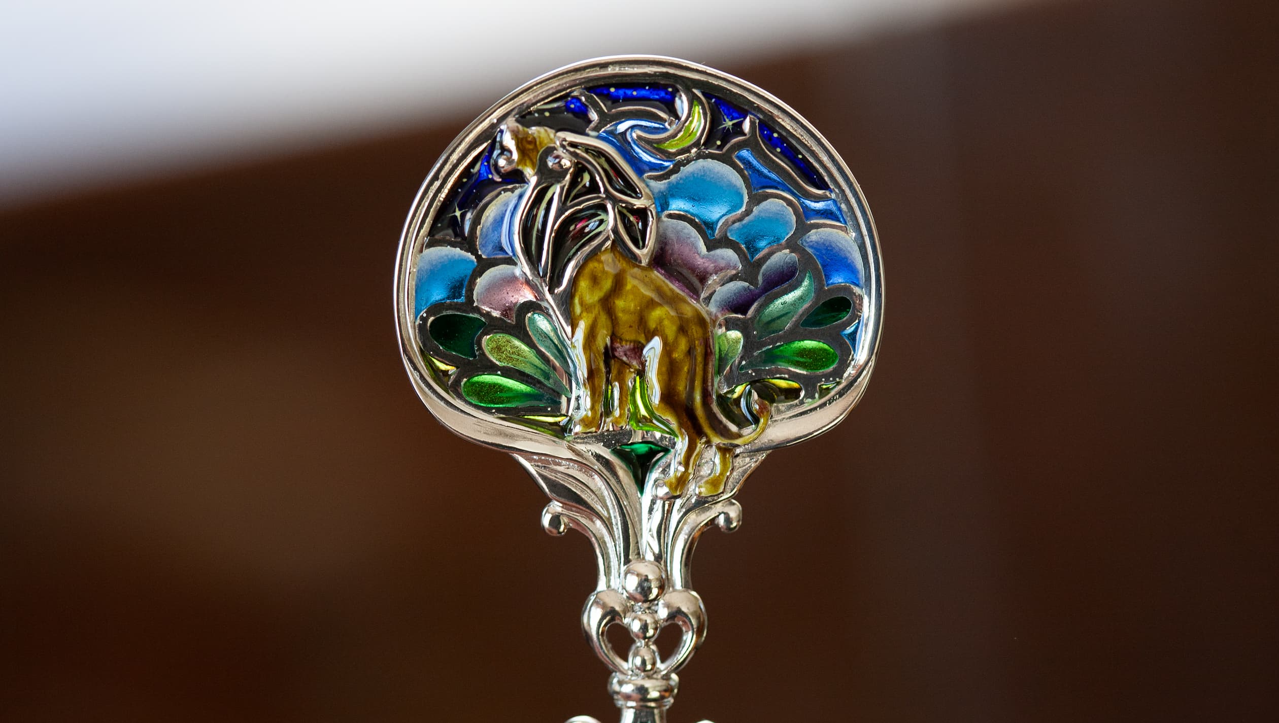 Витражная ложка с золотым львом, освещенная дневным светом Серебряная чайная ложка со львом в технике витражной и перегородчатой эмали, изготовленная мастерской Хризолит. Фото 7.